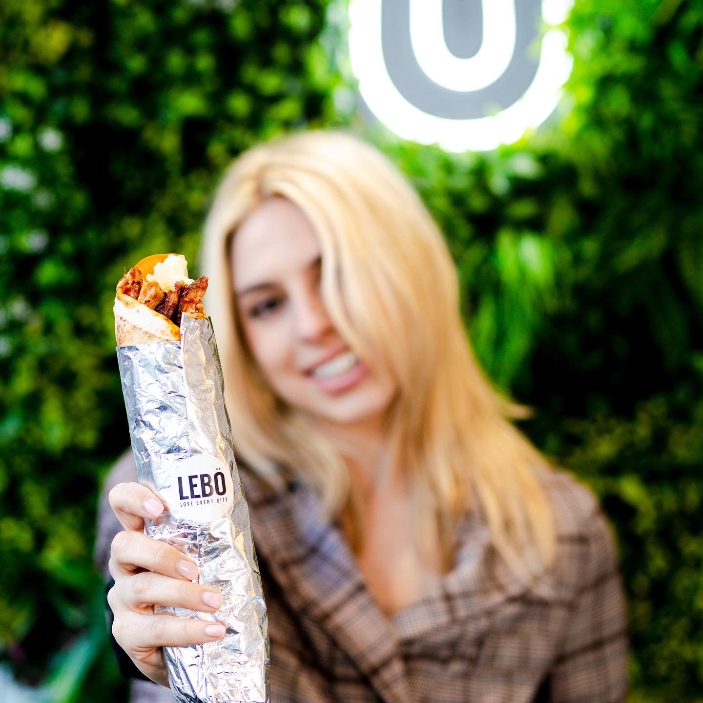 Model holding a shawarma wrap from EAT LEBO