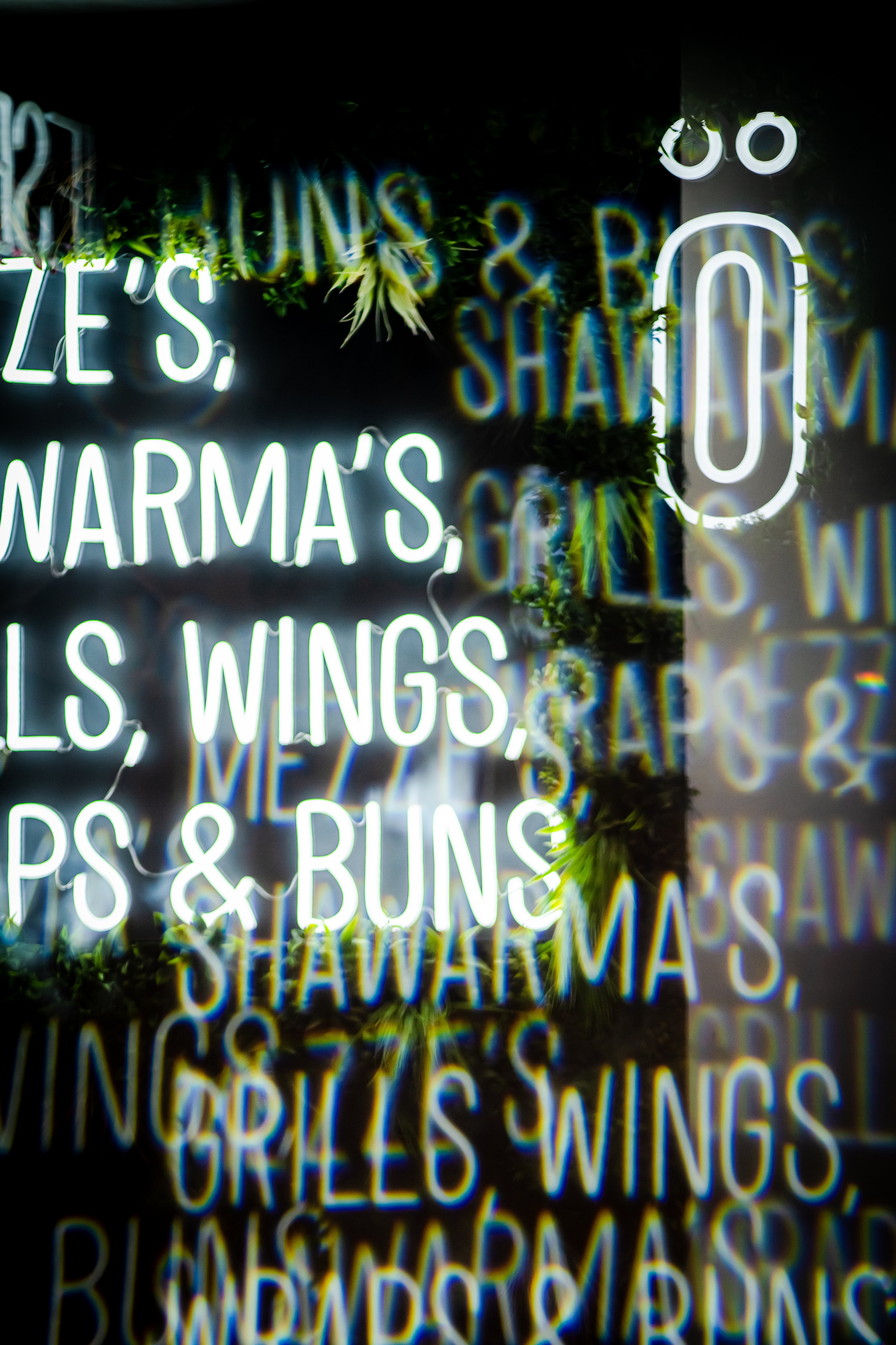 Neon Sign saying Mezzes, Wraps, Wings, Buns